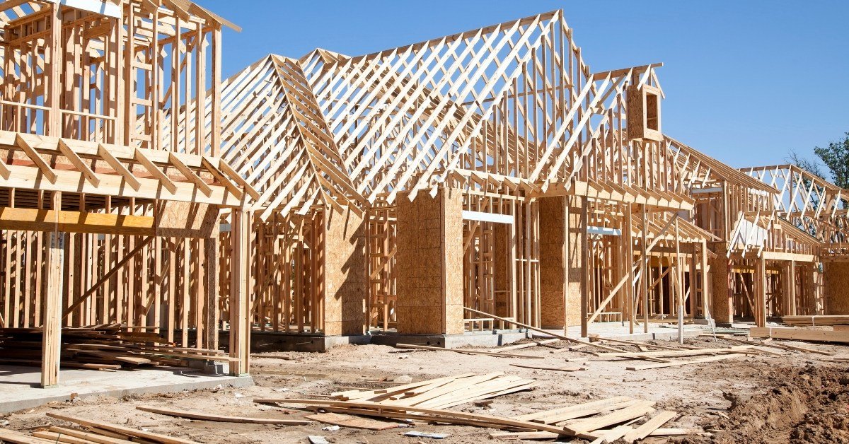Row of new wood-frame homes under construction in a subdivision