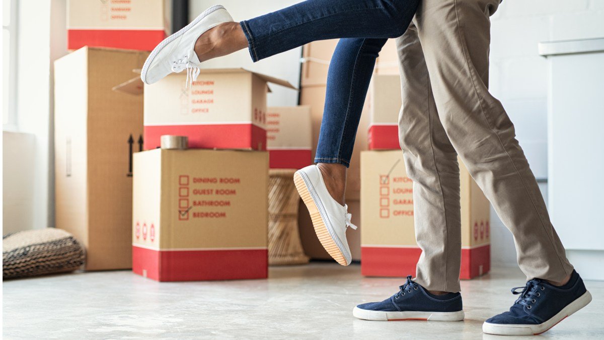Couple embracing among moving boxes in a new home