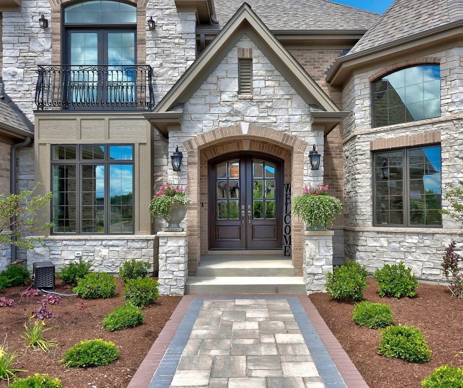 Stone veneer luxury home entrance with arched double doors
